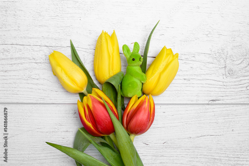 Easter rabbit and tulips over wooden background. Easter rabbit and tulips over wooden background.