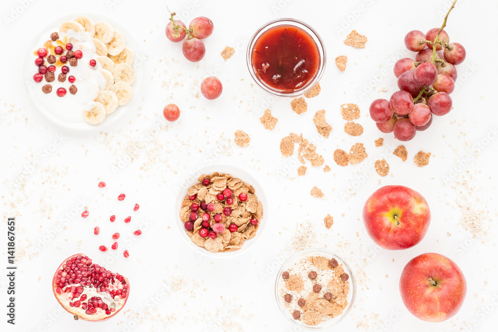 Healthy breakfast with yogurt, muesli, fresh fruits and berries, cereal, nuts on white background. Flat lay, top view. Healthy breakfast with yogurt, muesli, fresh fruits and berries, cereal, nuts on white background. Flat lay, top view.