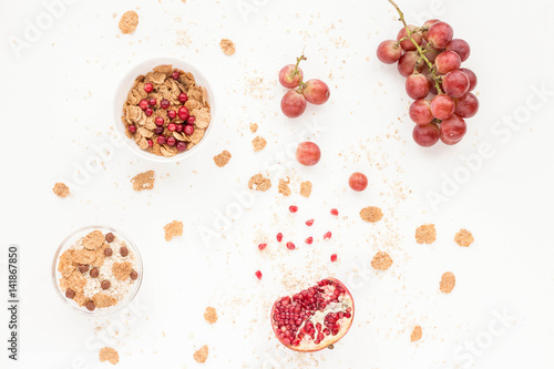 Healthy breakfast with yogurt, muesli, fresh fruits and berries, cereal, nuts on white background. Flat lay, top view.