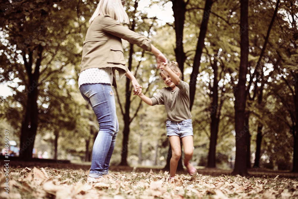Fototapeta premium Mother and daughter playing in the park.