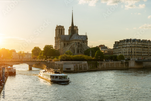 Notre Dame de Paris with cruise ship on Seine river in Paris, France