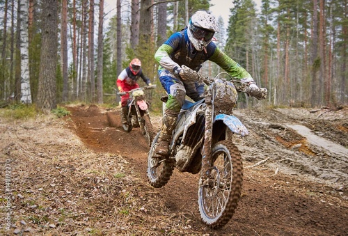 Motocross drivers in competition on the enduro race track photo