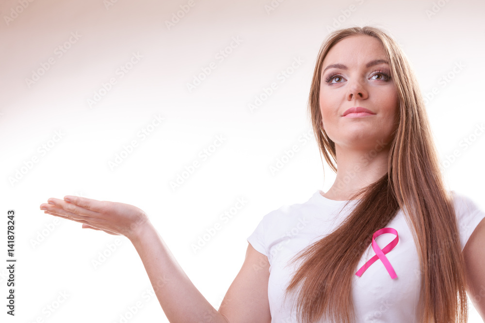 Woman pink cancer ribbon on chest holds open hand Woman pink cancer ribbon on chest holds open hand
