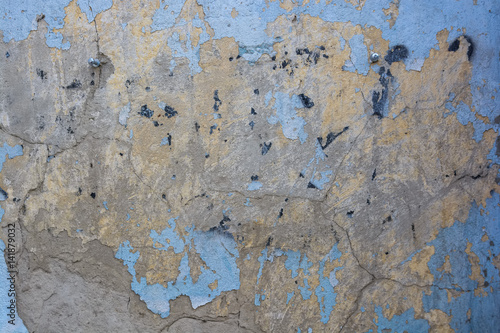 Blue cracked painting on old plaster wall surface