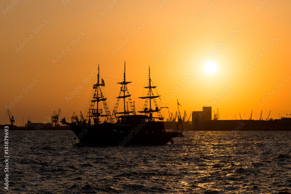 Ship at sunset. Tourist boat in the sea in the rays of the setting sun