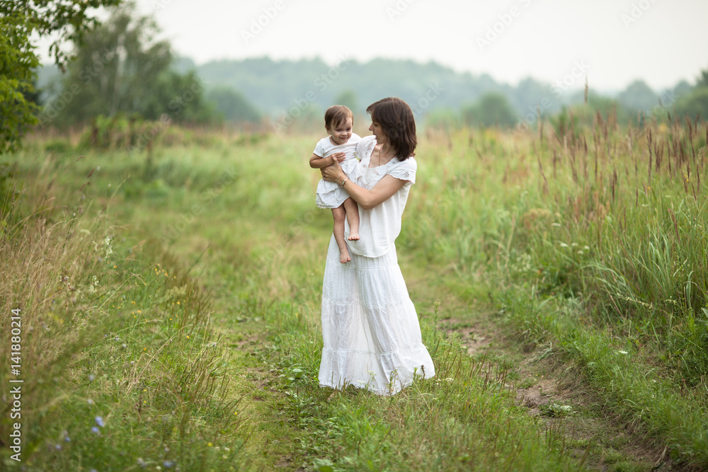 happy young mother with toddler in arms walking happy young mother with toddler in arms walking