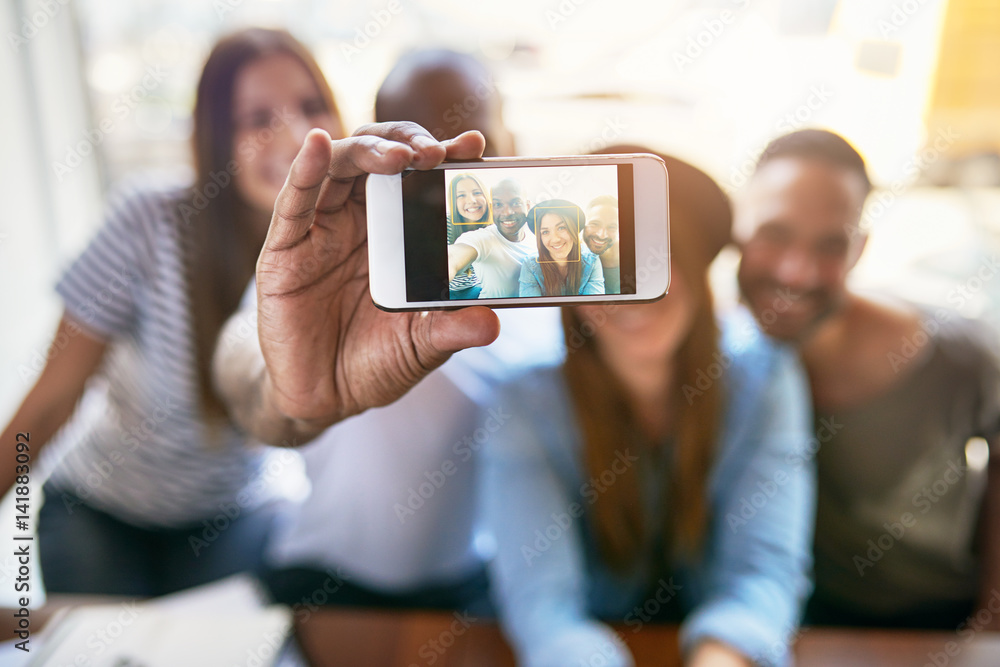 Group of friends taking selfie with phone