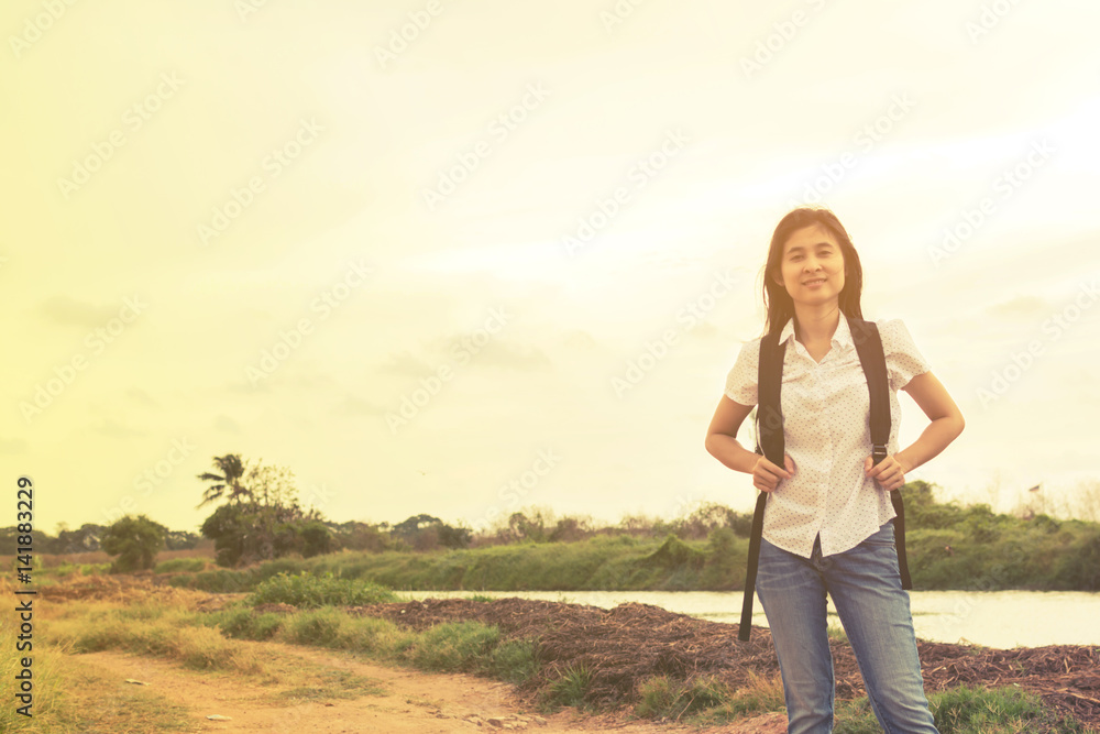 young traveler woman walking along country road. young traveler woman walking along country road.