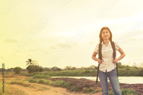 young traveler woman walking along country road.