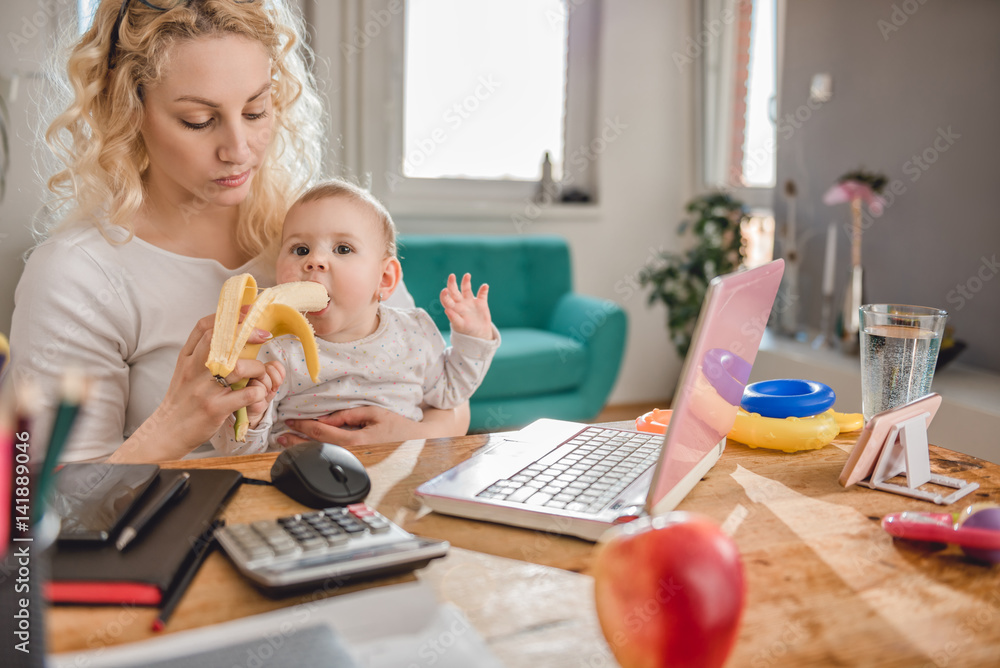 Mother feeding baby at home office Mother feeding baby at home office