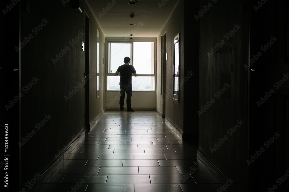 Silhouette of man standing alone,Sad and Serious Man stand alone of close room hospital., Dramatic moment.