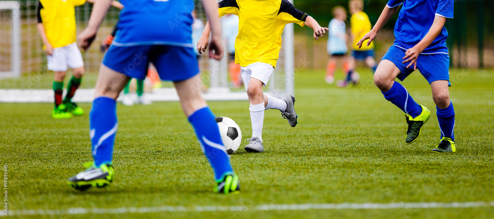Football Player Running with the Ball on the Pitch. Footballers Kicking Football Match on the Pitch. Young Teen Soccer Game. Youth Sport Horizontal Background