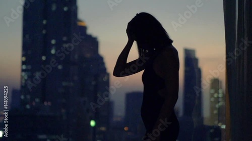 Sad, desperate woman walking by window at home at night, super slow motion

