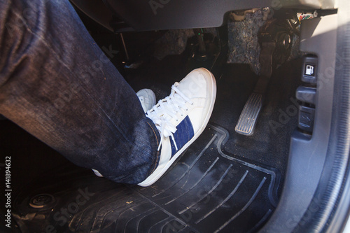 push the brake pedal of the car / brake the car photo