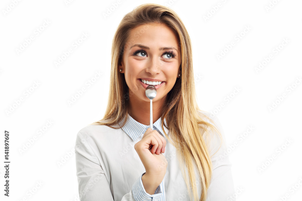 Portrait of young smiling woman with spoon in her mouth isolated on white