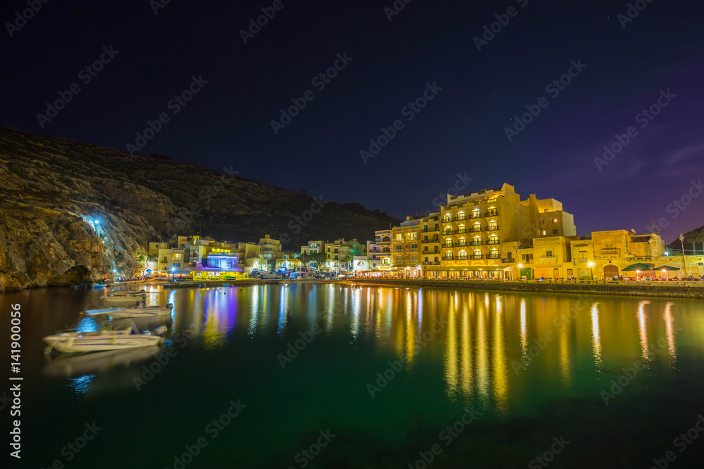 Xlendi, Gozo - Beautiful aerial view over Xlendi Bay by night with restaurants, boats and busy night life on the Island of Gozo