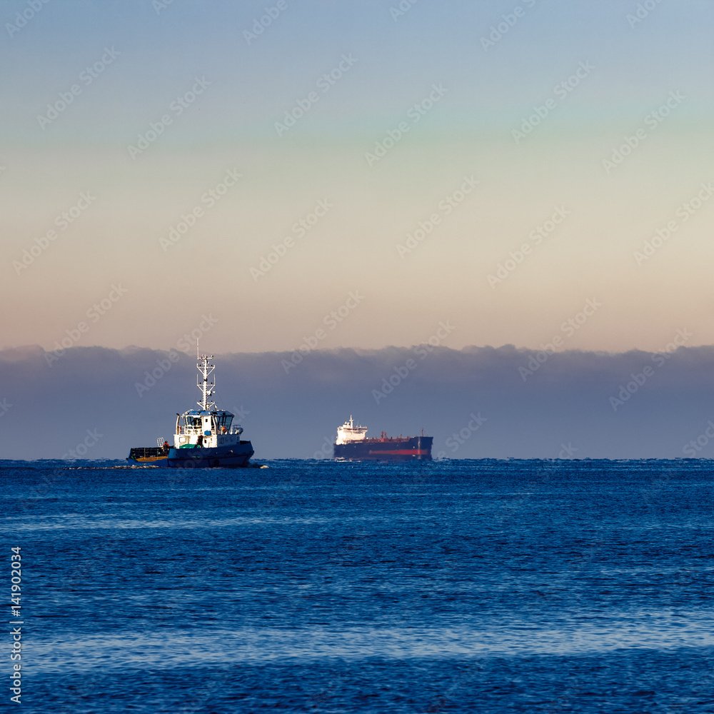 Blue small tug ship leaving Riga and entering the Baltic sea