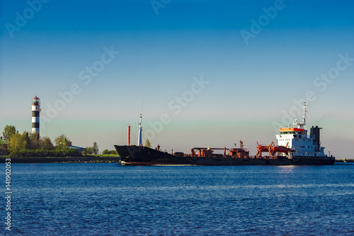 Black cargo oil tanker entering the port of Riga at sunny day © InfinitumProdux