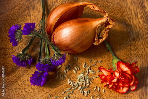 Wooden board with appetizing and colorful array of shallots,anise seeds and flowers