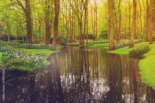 Colorful river, grass and flowerbed in dutch garden 'Keukenhof', Holland, retro toned