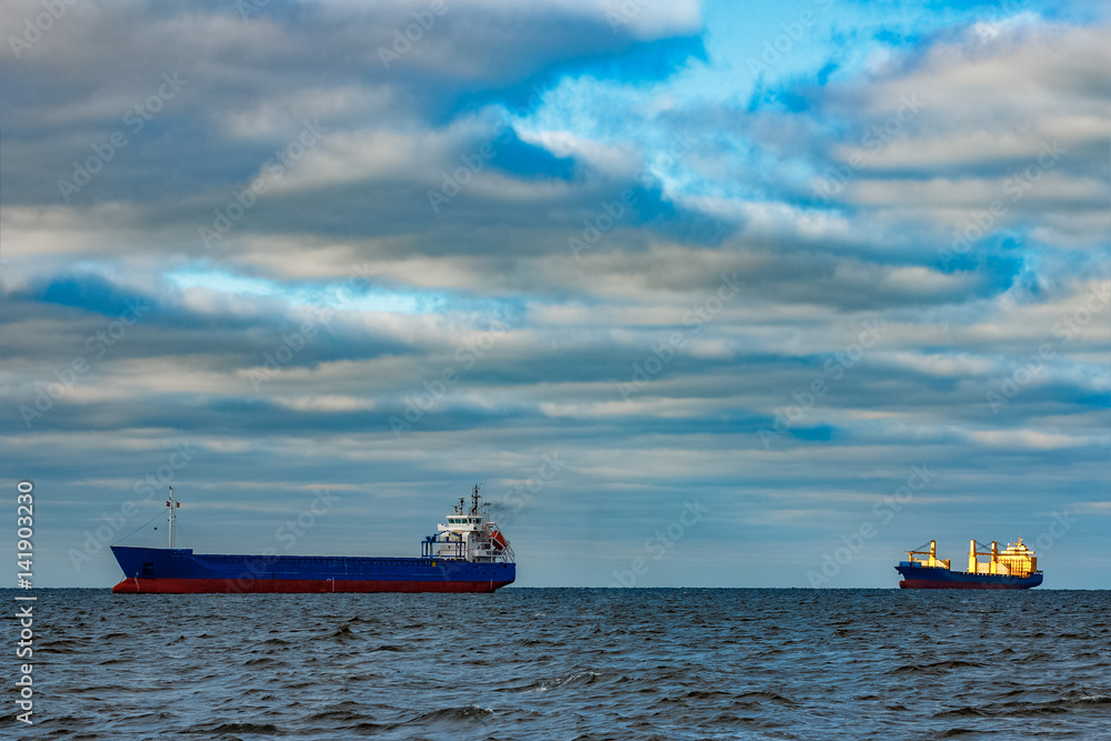Blue cargo ships moored in still Baltic sea water Blue cargo ships moored in still Baltic sea water