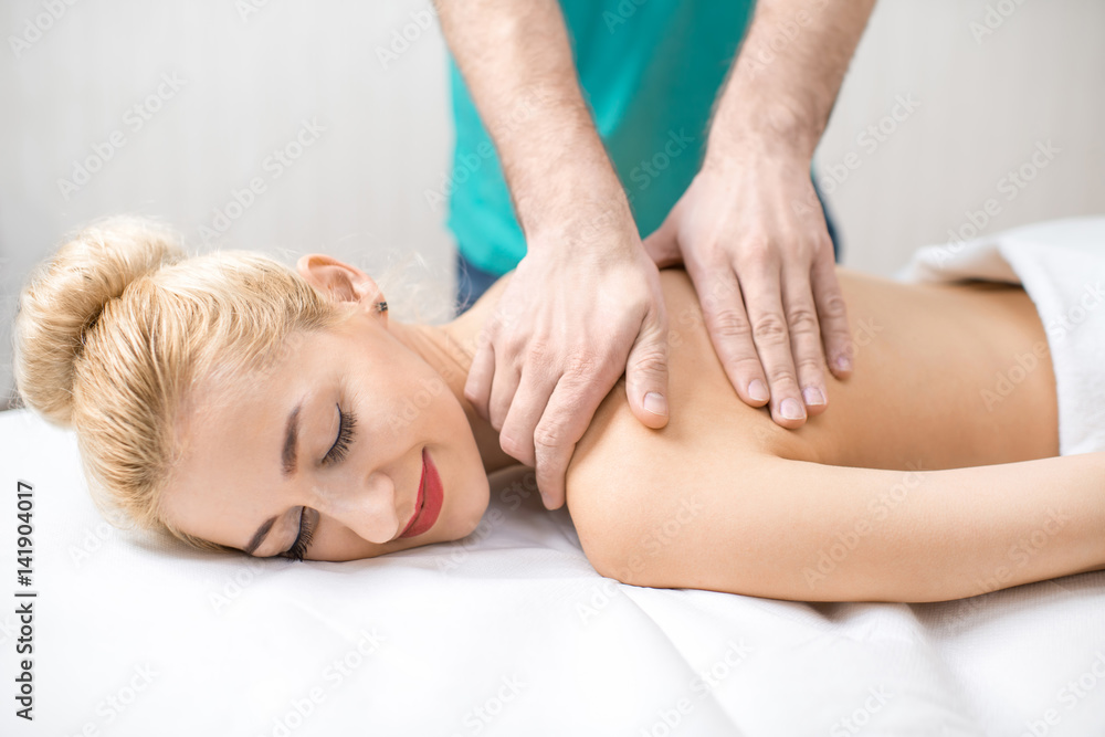 Beautiful woman getting professional massage on her back lying on the couch in the Spa Beautiful woman getting professional massage on her back lying on the couch in the Spa