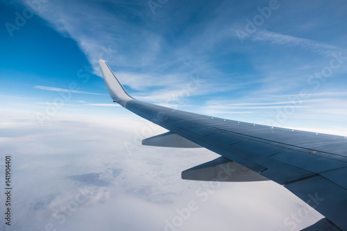 Wing of an aircraft and cloudy sky