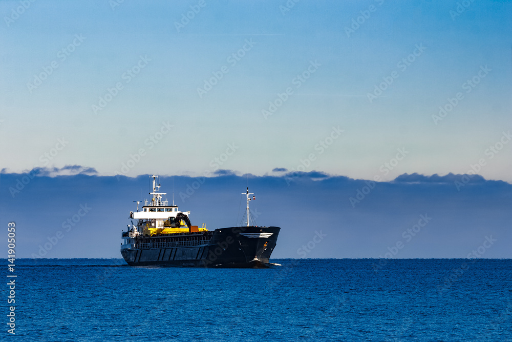 Black cargo ship with long reach excavator moving by baltic sea Black cargo ship with long reach excavator moving by baltic sea