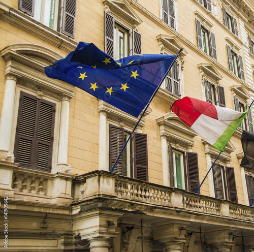 ROME, ITALY - JUNE 16, 2014: Europe Union flag in blue color with yellow stars representing the countries that are in, behind Italy flag. photo