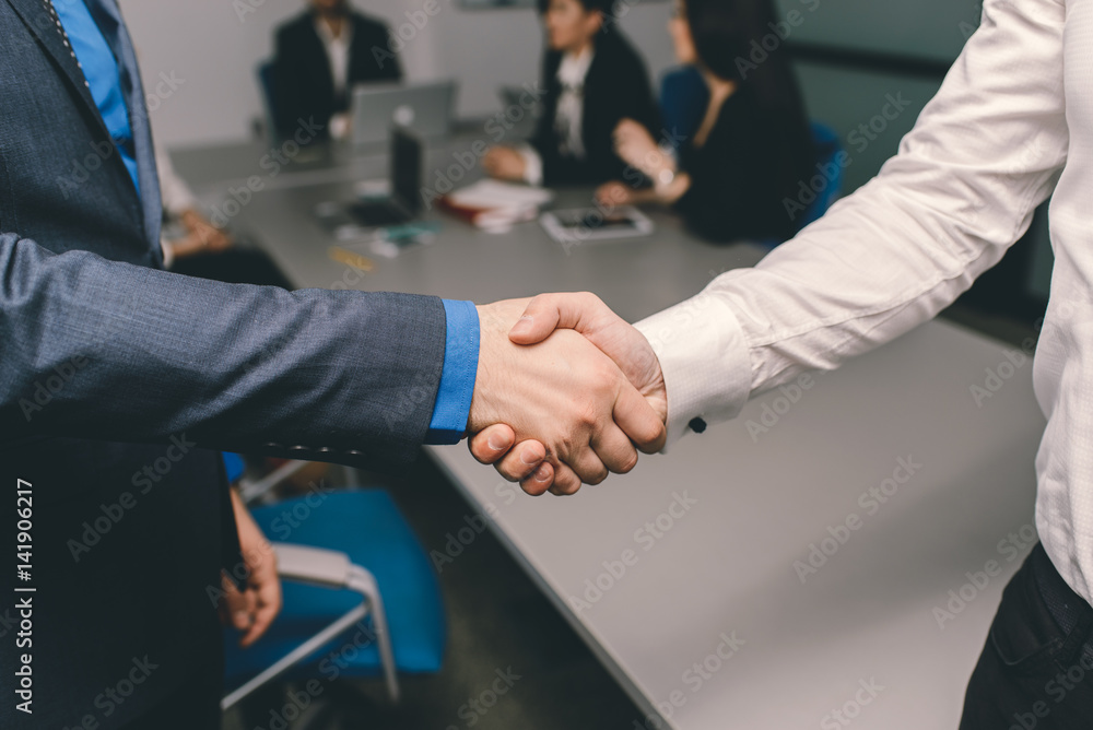 Two men handshaking in an office after successfull contract