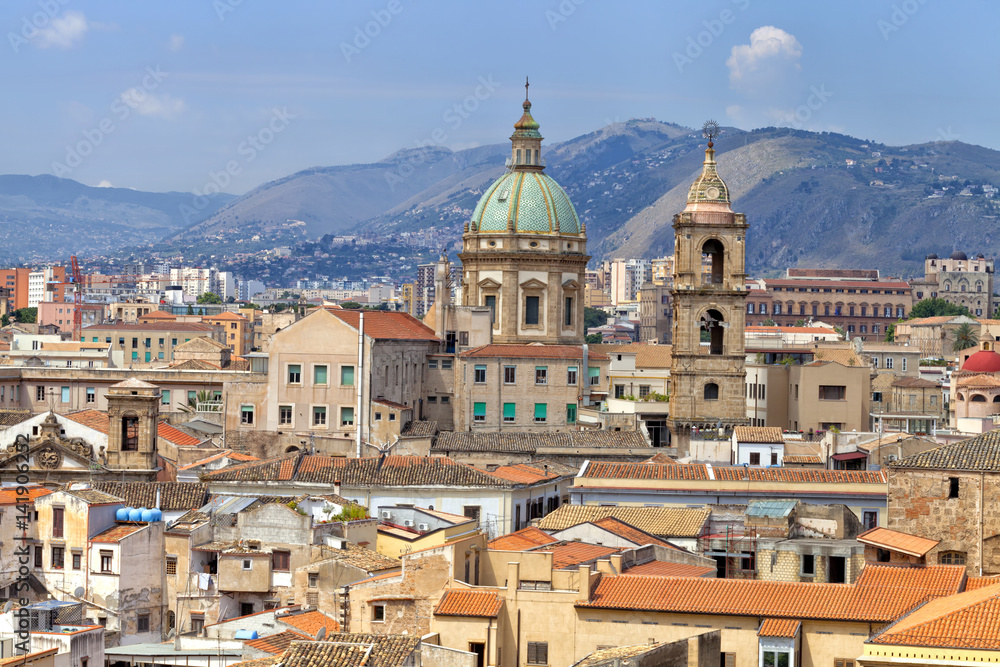 Sicilian town of Palermo skyline over roofs of historic buildings with the mountains in the background