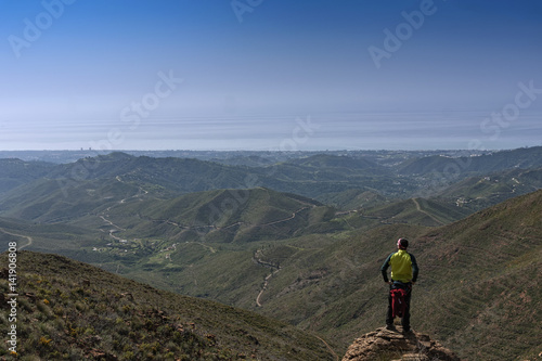 Cuadro en lienzo Hombre en la cima de la montaña que mira el paisaje montañoso