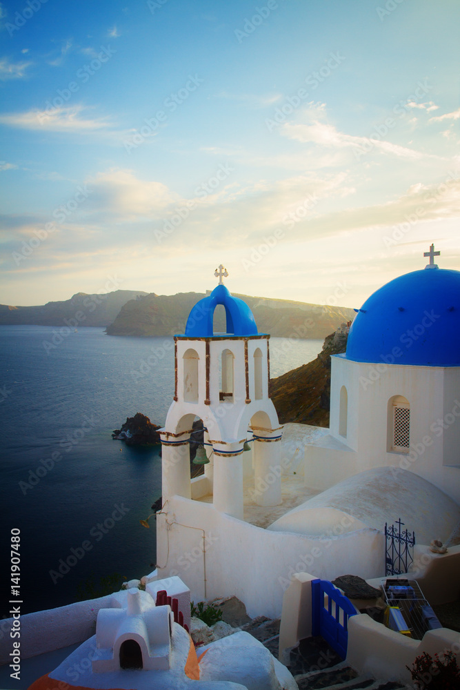 traditional greek village Oia of Santorini, with blue domes of churches at sunset, Greece, retro toned