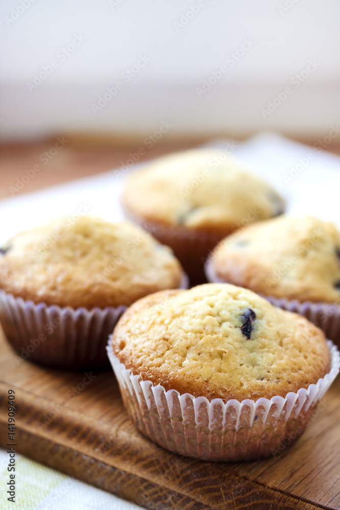Homemade muffins with blueberries on a wooden board Homemade muffins with blueberries on a wooden board