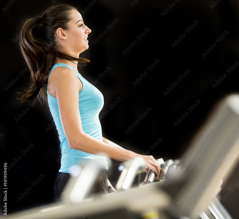 Fototapeta premium Young woman exercise on the treadmill at the gym