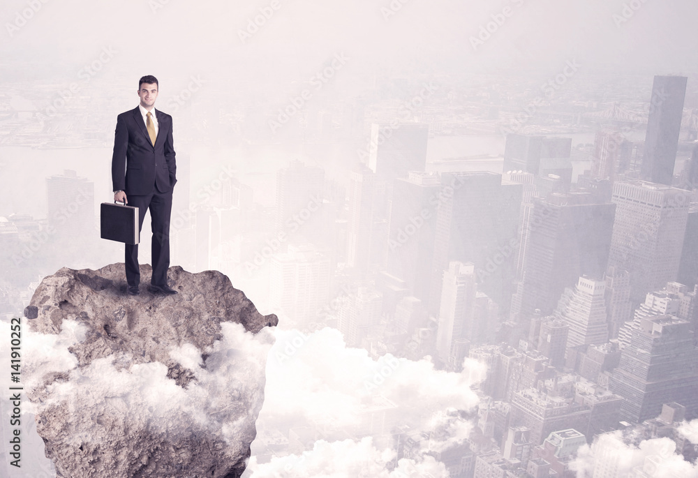 Winner business person standing on rock Winner business person standing on rock