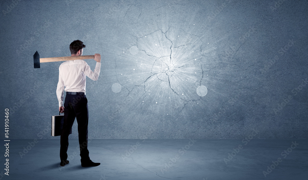 Fototapeta premium Business man hitting wall with a hammer