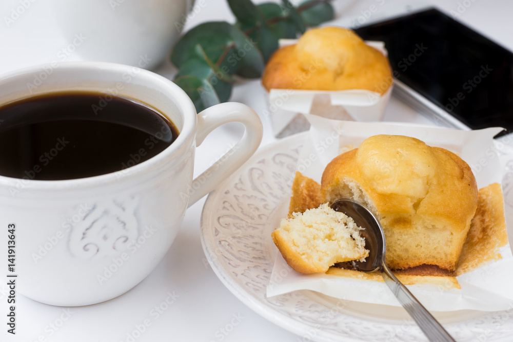 Cup of coffee, pastry on plate, smartphone, eucalyptus branch on white table, female business, style image for social media Cup of coffee, pastry on plate, smartphone, eucalyptus branch on white table, female business, style image for social media