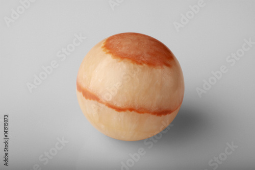 Polished round stone aragonite on a gray background. photo