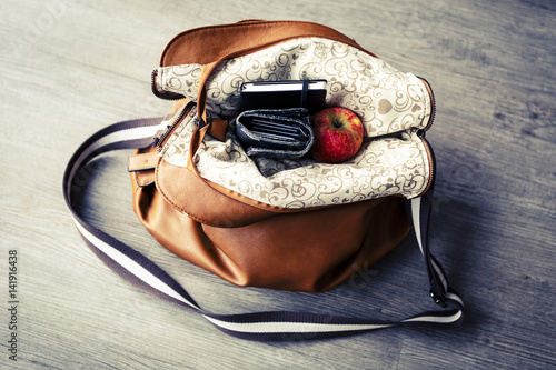 inside woman handbag on the wooden floor