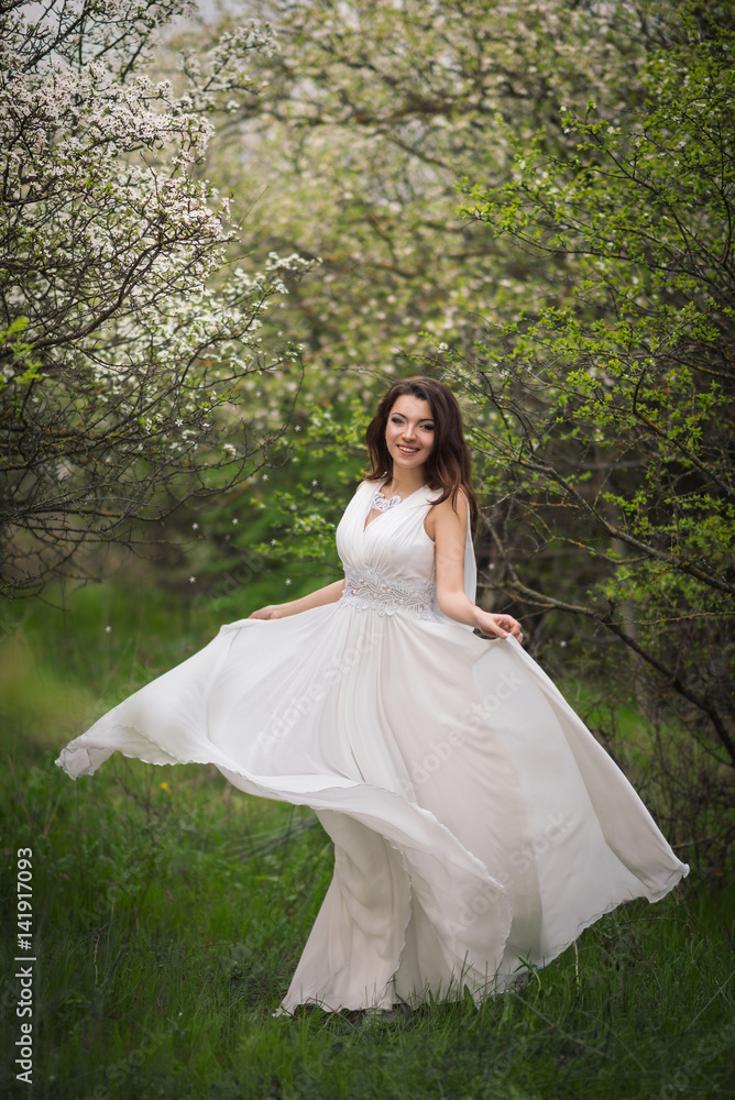 Girl in white dress in blooming garden Girl in white dress in blooming garden