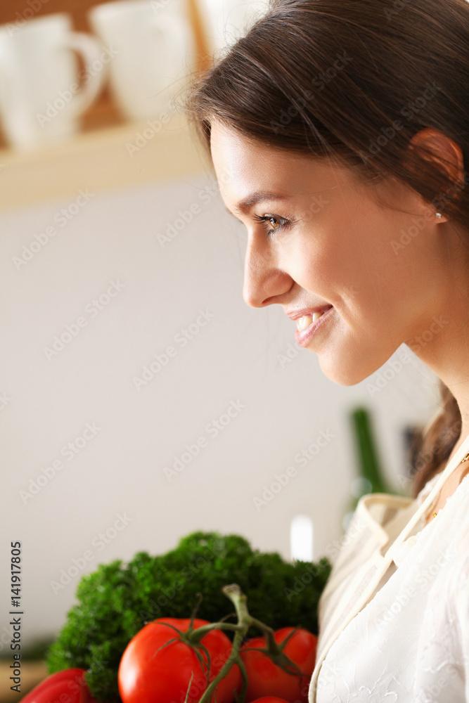 Young woman standing near desk in the kitchen Young woman standing near desk in the kitchen