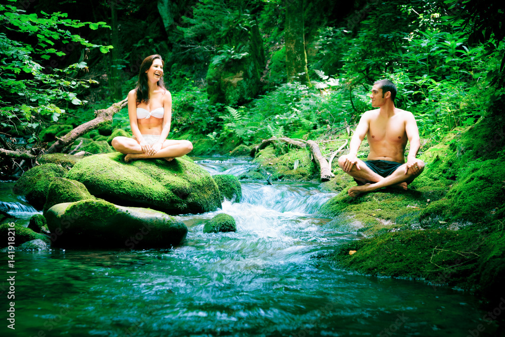Couple Doing Yoga By The River Couple Doing Yoga By The River
