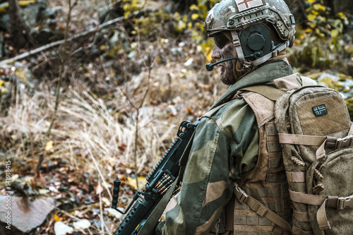 Norwegian Rapid reaction special forces FSK soldier patrolling in the forest. Field camo uniforms  combat helmet and eye-wear goggles are on