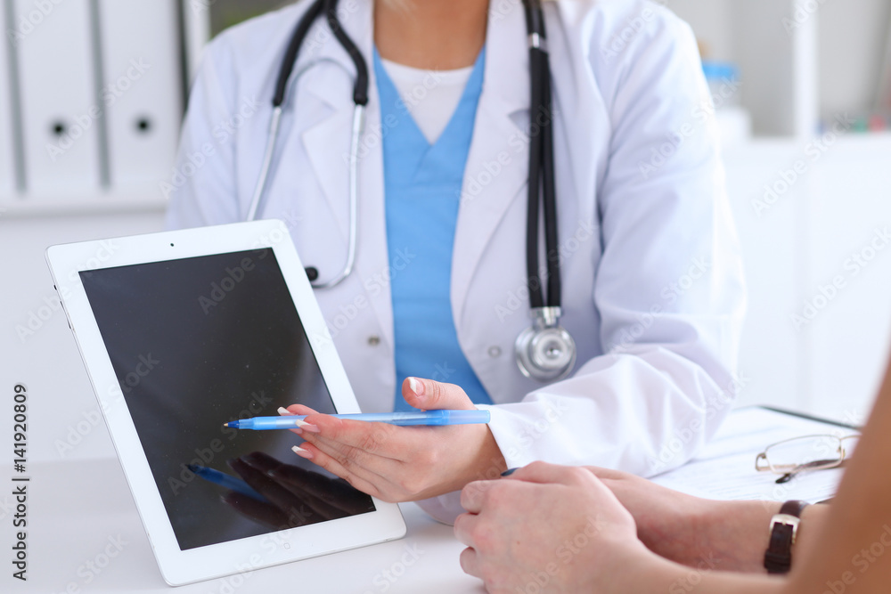 Close up of a doctor and patient hands while phisician pointing into tablet computer monitor. Medicine and health care concept Close up of a doctor and patient hands while phisician pointing into tablet computer monitor. Medicine and health care concept