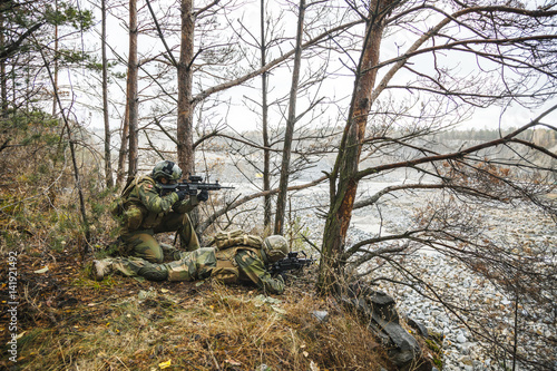 Norwegian Rapid reaction special forces FSK soldiers in field uniforms scouting in the forest trees