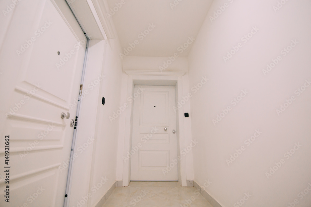 Corridor in a building. White staircase. Interior hallway with doors to the neighbors.