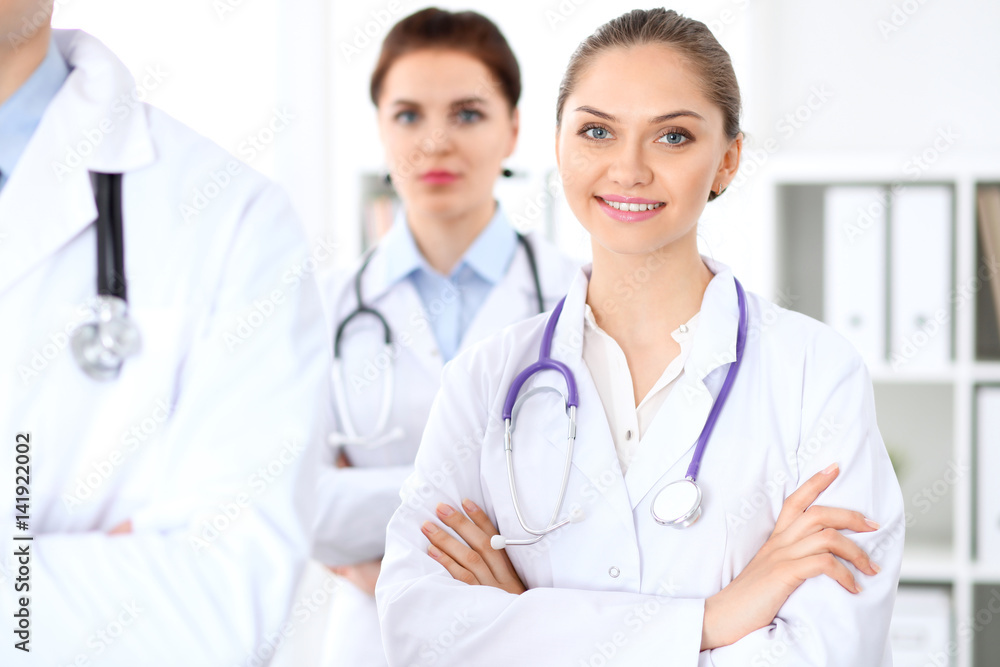 Happy female doctor with medical staff at the hospital. Successful team at health care concept Happy female doctor with medical staff at the hospital. Successful team at health care concept