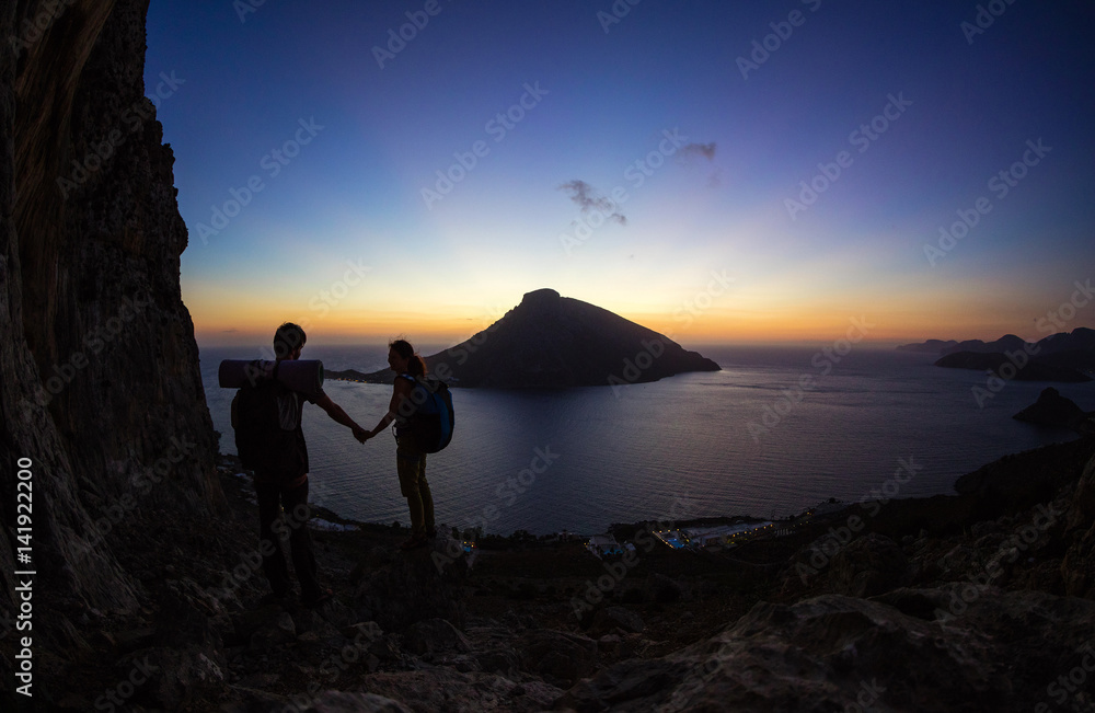 Young couple of rock climbers at sunset