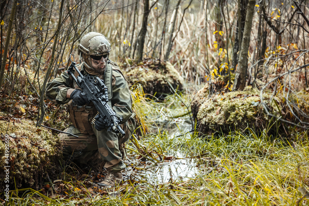Adquisición Sur oeste Joven Norwegian Rapid reaction special forces FSK soldier sitting on the swamp.  Field camo uniforms, combat helmet and eye-wear goggles are on foto de  Stock | Adobe Stock